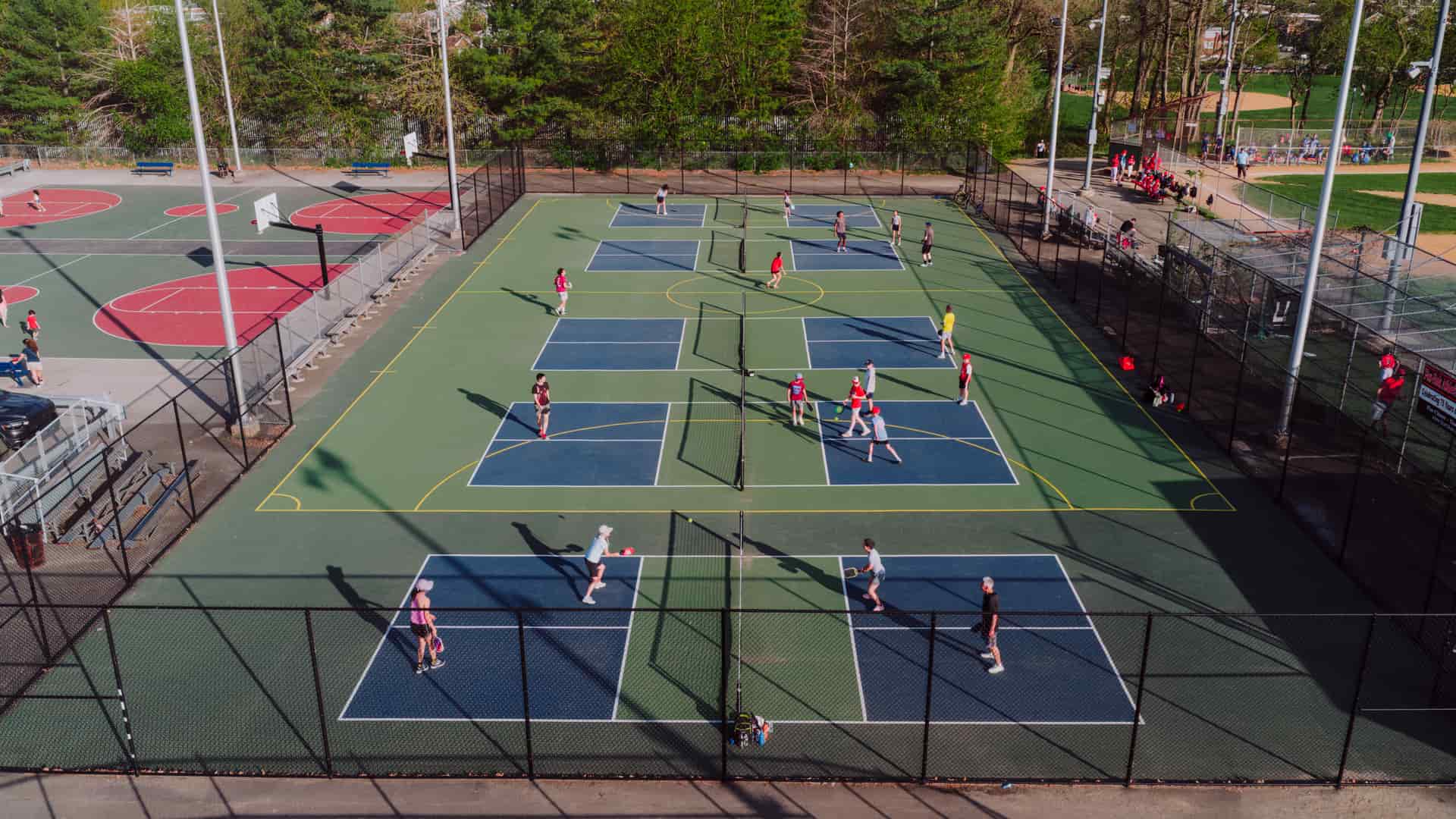 Older adults enjoying a game of pickleball on a bright outdoor court